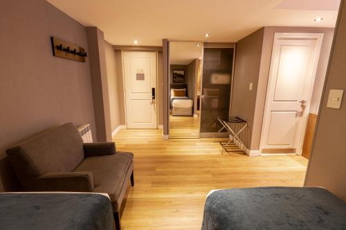 a living room with two beds and a couch at Alto Andino Hotel in Ushuaia