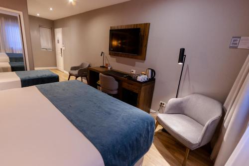 a hotel room with a bed and a desk and chair at Alto Andino Hotel in Ushuaia