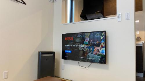 a flat screen tv hanging on a wall at Holiday home Furinkazan 風林火山 in Fujikawaguchiko