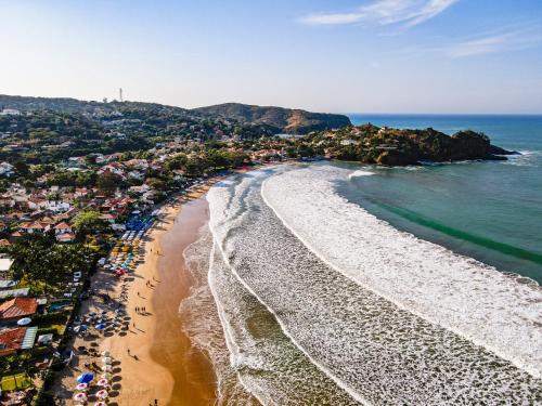 an aerial view of a beach with umbrellas and the ocean at Pousada Alforria in Búzios