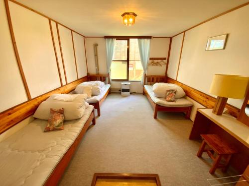 a room with couches and chairs in a room at Mashuko Youth Hostel in Teshikaga