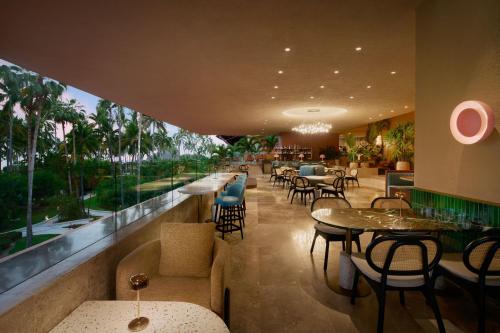 a restaurant with tables and chairs and a large window at The Westin Resort & Spa, Puerto Vallarta in Puerto Vallarta