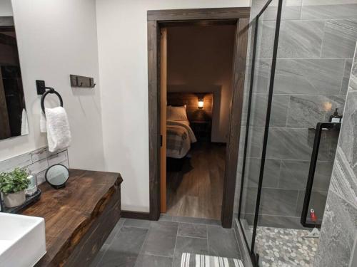 ein Bad mit einer Dusche und ein Schlafzimmer mit einem Bett in der Unterkunft Skyline Suite 2Bdrm King in Valemount