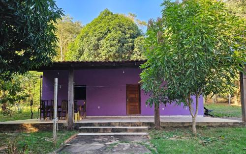 a purple house with a tree in front of it at Casa de Praia Pindobal in Santarém