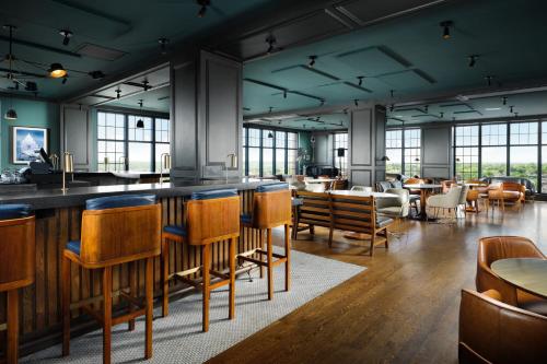 a restaurant with a bar with wooden chairs and tables at The Westin Portland Harborview in Portland