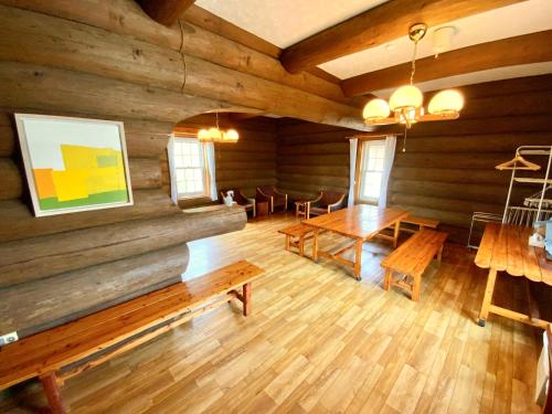 a room with wooden walls and wooden tables and benches at Mashuko Youth Hostel in Teshikaga
