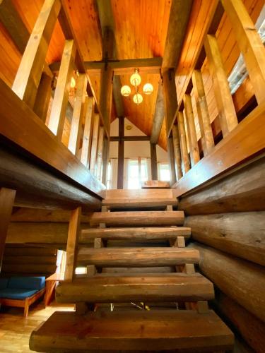 a wooden staircase in a room with wooden ceilings at Mashuko Youth Hostel in Teshikaga