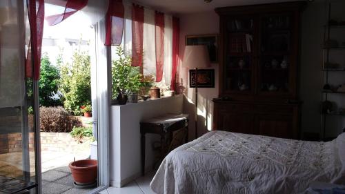 a bedroom with a bed and a sliding glass door at Chambres d'hôtes Issy-Paris in Issy-les-Moulineaux