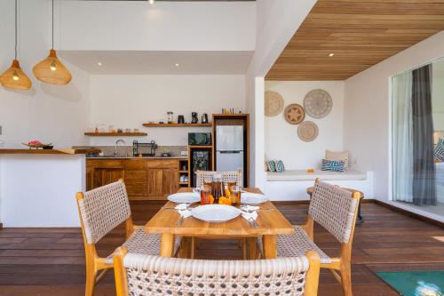 une salle à manger avec une table et des chaises en bois dans l'établissement Villa Eden at Nyanyi, à Canggu