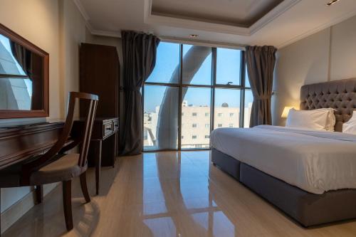 a bedroom with a bed and a desk and a piano at Gazala Hotel in Riyadh