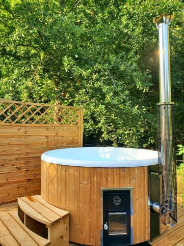 un jacuzzi avec une terrasse en bois avec un banc dans l'établissement Cocon du Bonheur, à Marsaneix