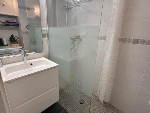 une salle de bain blanche avec un lavabo et une douche dans l'établissement Appartement confort 3P · Proche pistes · WIFI · 6 personnes - FR-1-425-225, à Arâches-la-Frasse