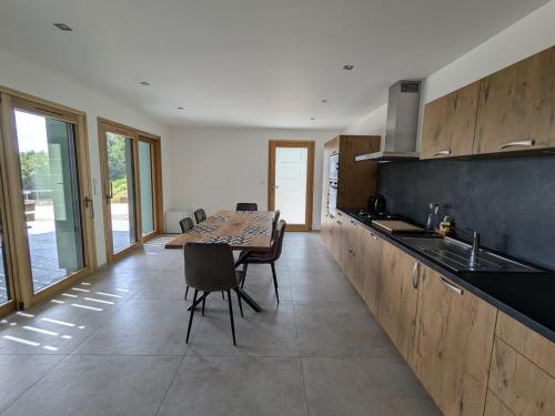 - une cuisine avec une table, des chaises et un comptoir dans l'établissement Gîte Montagne avec Piscine Chauffée, Spa et Sauna - Les Roches - FR-1-589-656, à Le Val-dʼAjol
