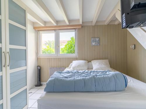 un lit dans une chambre avec une fenêtre dans l'établissement T3 Biscarrosse Plage, 5 pers, parking, proche océan, ménage inclus - FR-1-319-577, à Biscarrosse