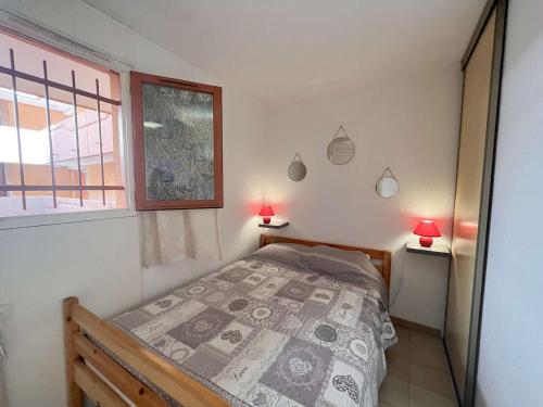 - une chambre avec un lit, une fenêtre et 2 lampes dans l'établissement Studio cabine climatisé avec terrasse et garage - 4 couchages, St Raphaël - FR-1-226A-180, à Saint-Raphaël