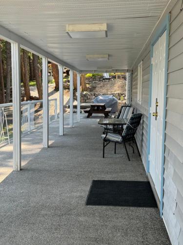 a porch with a table and chairs on a house at Blarney Place Retreat in Vernon