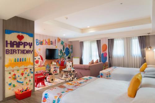 a childrens bedroom with two beds and a happy birthday sign at E-DA Skylark Hotel in Dashu