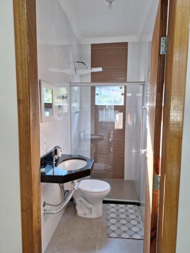 a bathroom with a toilet and a shower and a sink at Apartamento aconchegante in Sao Jose da Lapa