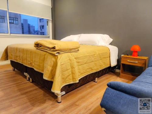 une chambre avec un lit avec une couverture jaune dessus dans l'établissement La Perla Deluxe Apart, à Salta