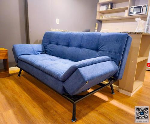 - un canapé bleu dans le salon dans l'établissement La Perla Deluxe Apart, à Salta