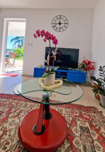 a living room with a glass table with flowers on it at Manapany and Rose in Le Butor