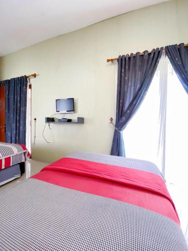 a bedroom with two beds and a window at the allegras house medan in Medan