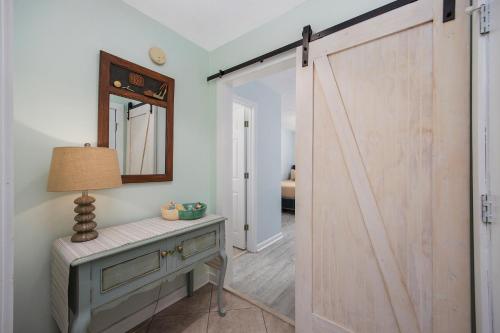 une porte de grange coulissante dans une pièce avec une table et une lampe dans l'établissement Beautiful and modern 3 BR Condo in True Blue!, à Pawleys Island