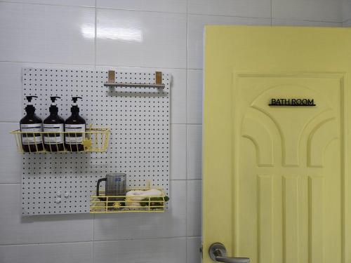 a yellow door in a bathroom with bottles of wine at Haekong's House in Seoul