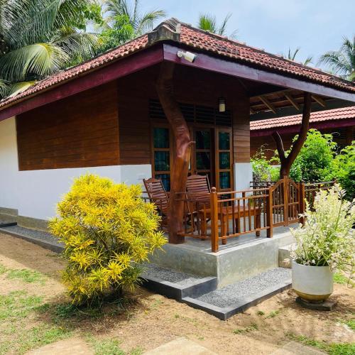 a house with a porch with chairs on it at Hanguk Lanka Lagoon Villa in Tangalle