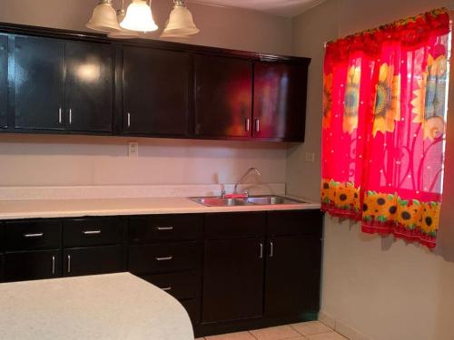 a kitchen with black cabinets and a sink at casa roble in Mexicali