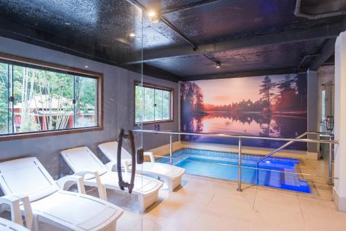 a room with a swimming pool with chairs and a painting at Hotel Vila Suíça 1818 in Nova Friburgo