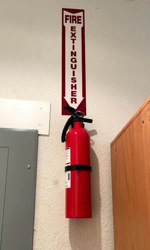 a fire extinguisher on the wall with a sign on it at Cozy Spot, 5 Min Away from Beach in Largo