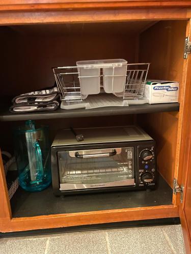 a microwave sitting on a shelf in a cabinet at Cozy Spot, 5 Min Away from Beach in Largo