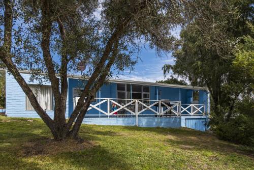 a blue building with a tree in front of it at Blueshack - Walking Distance To Foreshore in Guilderton