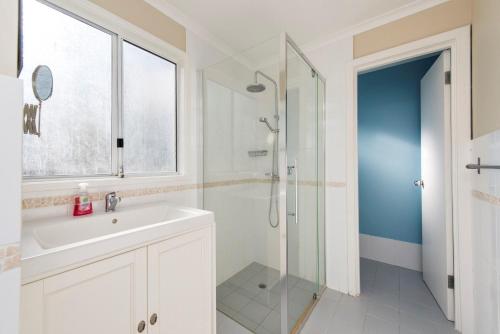 un baño con lavabo y ducha en Seaclusion Cottage - Modern renovated beach house, en Guilderton