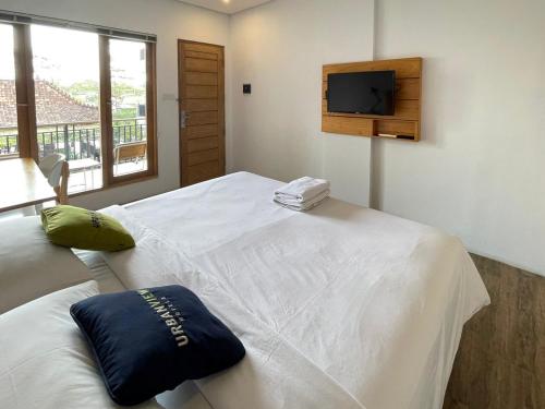 Una cama o camas en una habitación de Urbanview Code Riverstay Yogyakarta