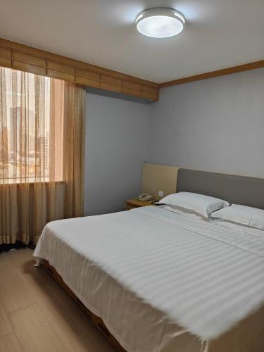 a bedroom with a large bed and a window at Guangdong Hotel (Zhuhai) in Zhuhai