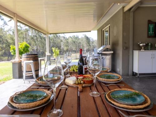 a wooden table with wine glasses and food on it at Ponderosa Homestead in Branxton