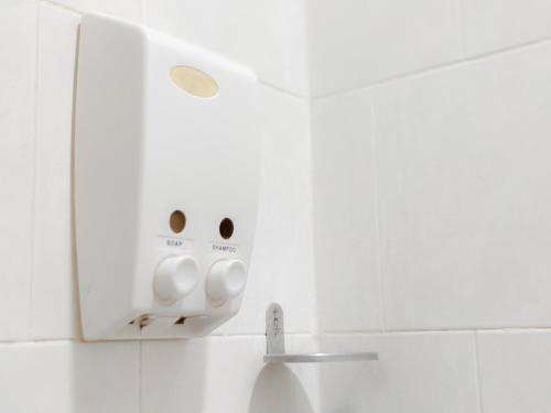 a white bathroom with a light on the wall at Angel Park Residence in Pattaya North