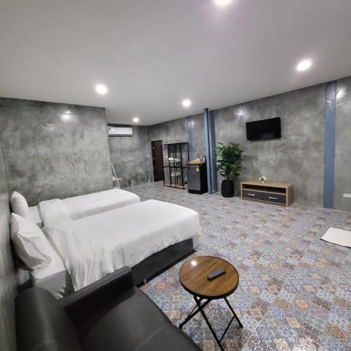 a bedroom with a bed and a couch and a tv at Goldengold (Khaoyai) Resort & Spa in Mu Si