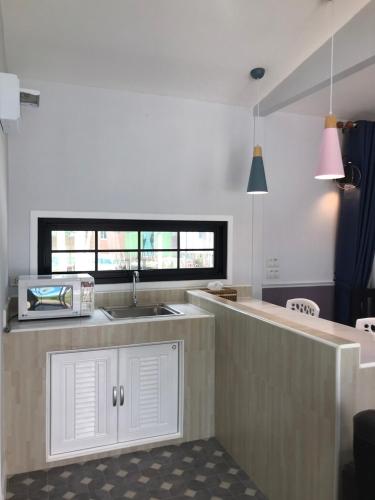 a kitchen with white cabinets and a sink and a window at Goldengold (Khaoyai) Resort & Spa in Mu Si