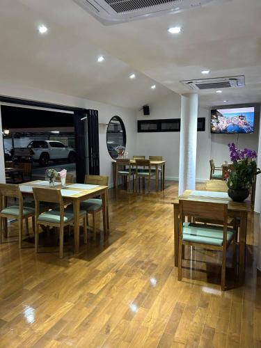 a dining room with tables and chairs and a tv at The European Chiang Mai in Chiang Mai