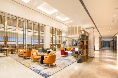 a lobby of a building with chairs and tables at Holiday Inn Lucknow Airport by IHG in Lucknow