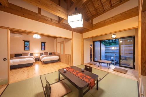 大村市にあるそのぎ茶温泉里山の湯宿 つわぶきの花のベッド2台とテーブルが備わる広い客室です。