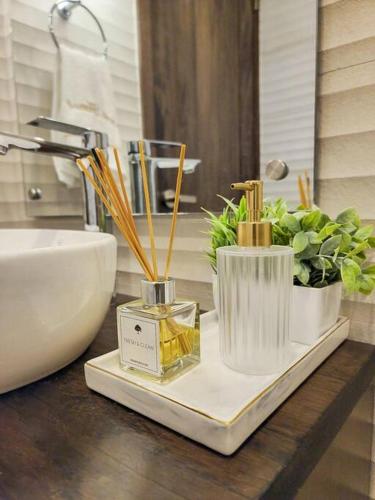 a bathroom counter with a bottle of perfume and plants at Luxury Apartment Downtown in Santiago de los Caballeros