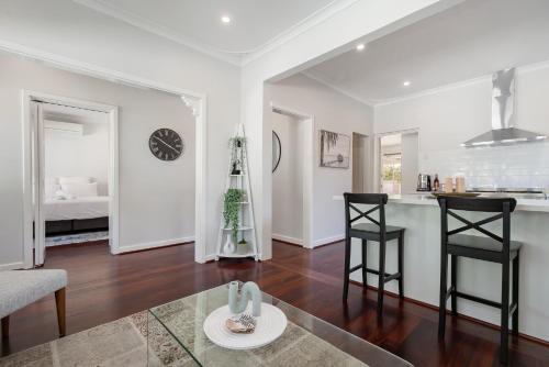 a kitchen and living room with a table and chairs at Guildford Cottage by Swan BnB Management in Perth