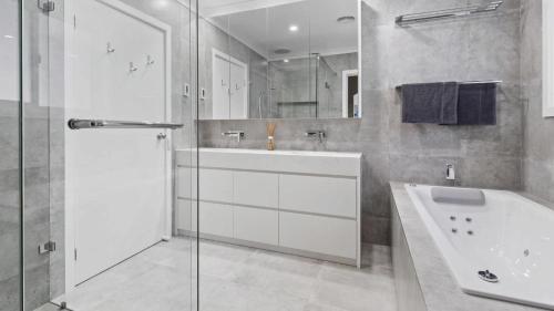 a bathroom with a tub and a sink and a shower at Sea For Days - Panoramic Bay Views in Rye in Rye