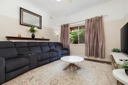 a living room with a couch and a table at North Beach Cottage by Swan BnB Management in Perth