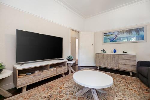 a living room with a large flat screen tv at North Beach Cottage by Swan BnB Management in Perth