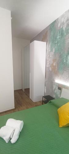 a bedroom with a green bed with towels on it at Re Giocondo Room in Foiano della Chiana